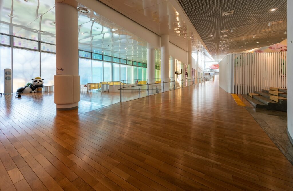 a large room with wooden floors and large windows